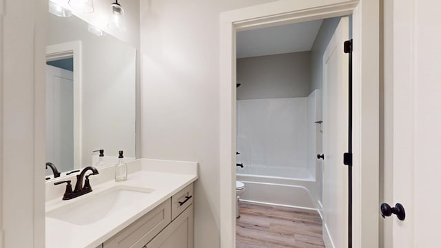 full bathroom featuring shower / bath combination, vanity, toilet, and hardwood / wood-style floors