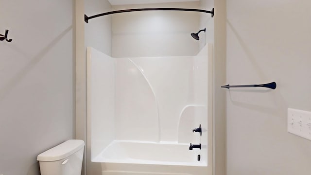 bathroom featuring shower / bathing tub combination and toilet