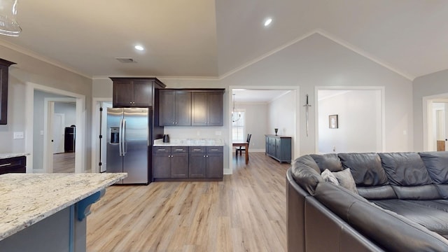 kitchen with light hardwood / wood-style flooring, dark brown cabinetry, light stone countertops, stainless steel fridge, and ornamental molding