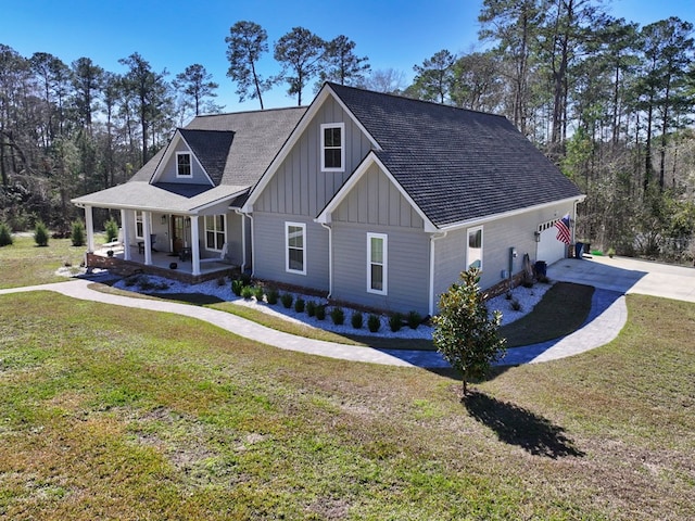 view of front facade with covered porch, a garage, and a front yard