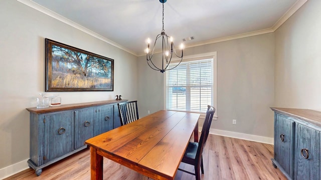 dining area with light hardwood / wood-style floors, crown molding, and a notable chandelier