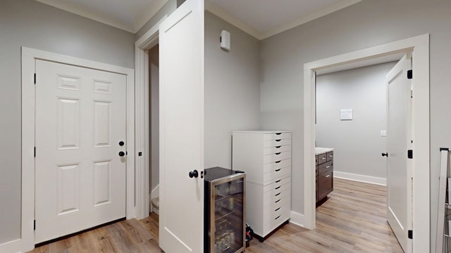 hallway featuring wine cooler, light hardwood / wood-style floors, and crown molding