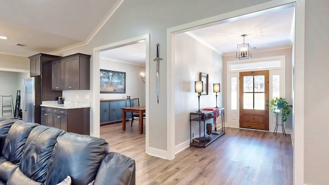 entrance foyer with light wood-type flooring and crown molding