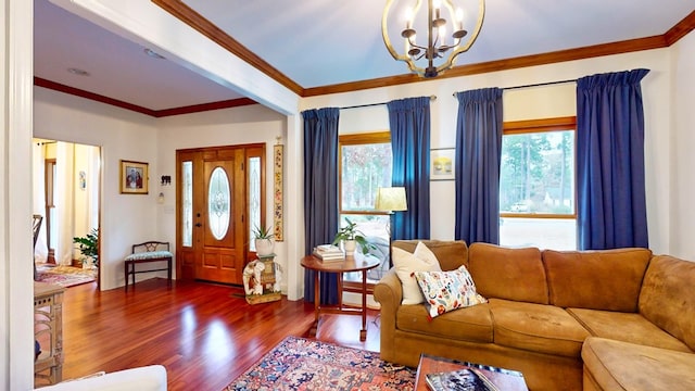 entryway with a notable chandelier, crown molding, and wood finished floors