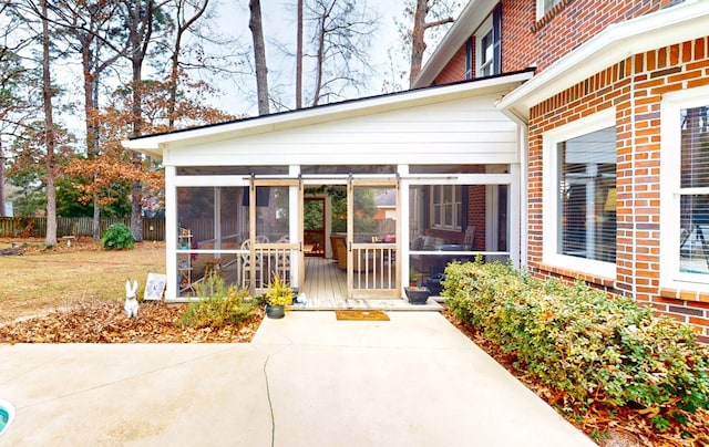 doorway to property with fence and brick siding