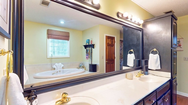 bathroom with double vanity, a garden tub, visible vents, and a sink