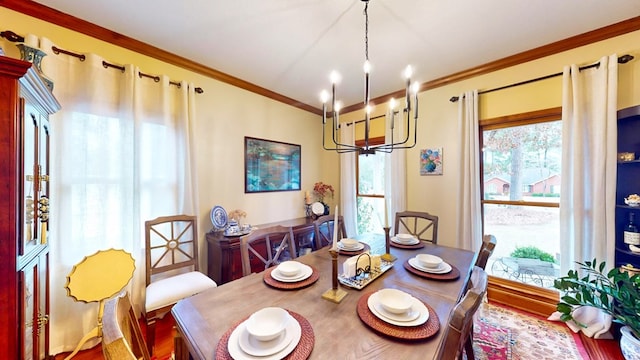 dining area featuring ornamental molding, plenty of natural light, and an inviting chandelier