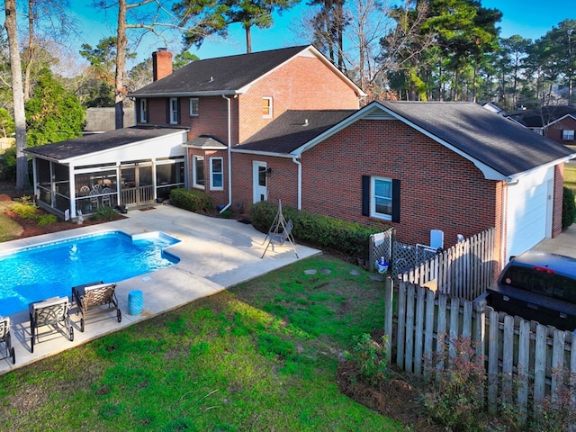 rear view of house with brick siding, a patio, a chimney, a sunroom, and fence