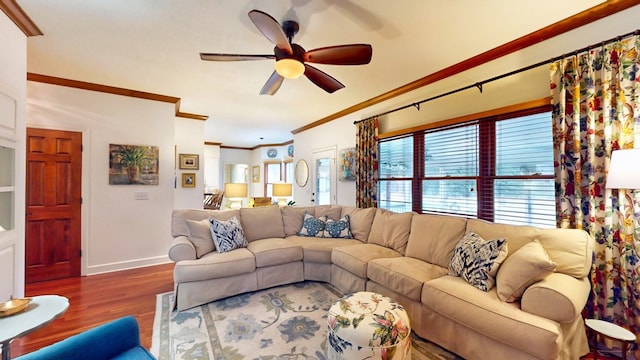 living room with a ceiling fan, crown molding, baseboards, and wood finished floors