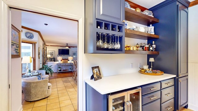 bar featuring wine cooler, crown molding, a dry bar, light tile patterned floors, and ceiling fan