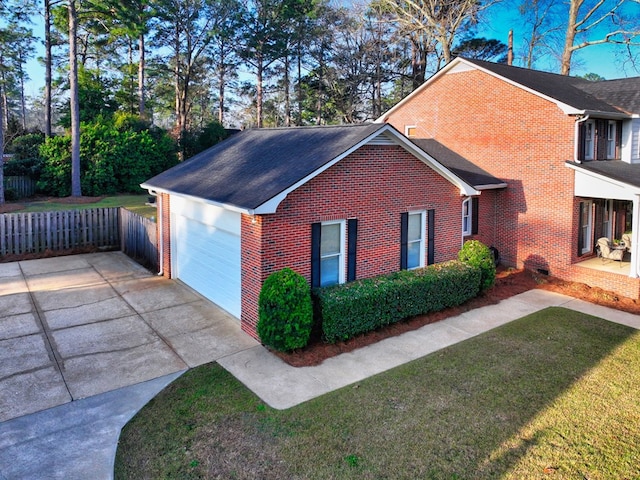 view of side of home featuring a shingled roof, brick siding, a yard, and driveway