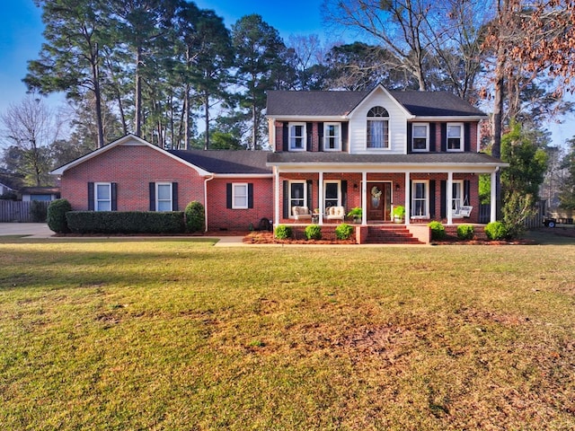 colonial inspired home featuring a porch, crawl space, brick siding, and a front lawn