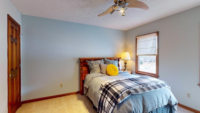 bedroom featuring light carpet, a textured ceiling, and baseboards