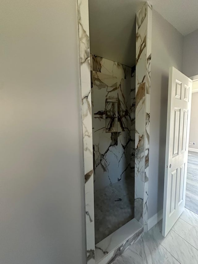 full bath featuring marble finish floor and a marble finish shower