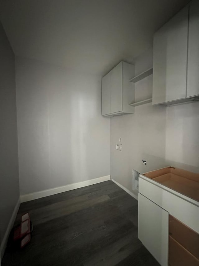 laundry room with cabinet space, baseboards, and dark wood finished floors