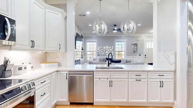 kitchen with stainless steel appliances, visible vents, open floor plan, white cabinetry, and a sink