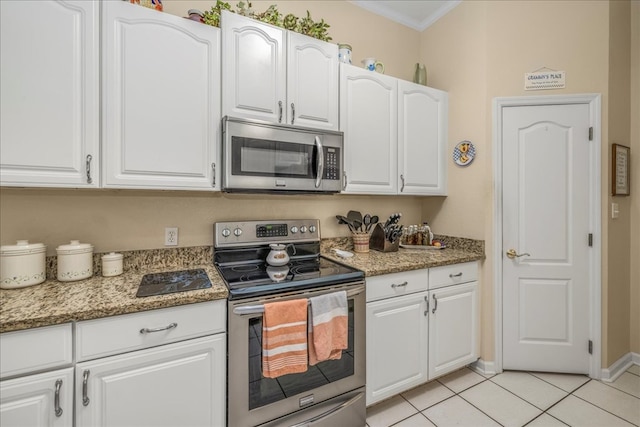 kitchen featuring light stone counters, stainless steel appliances, ornamental molding, white cabinets, and light tile patterned flooring