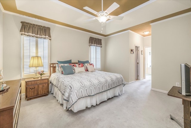 bedroom with light carpet, baseboards, a raised ceiling, a ceiling fan, and crown molding