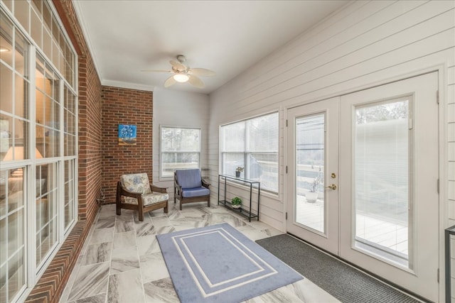 unfurnished sunroom featuring a ceiling fan and french doors