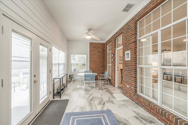 unfurnished sunroom featuring ceiling fan and visible vents