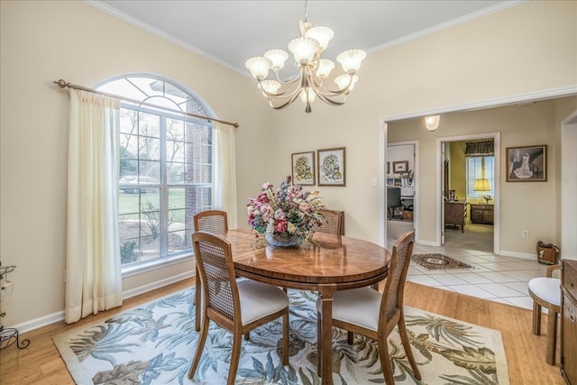 dining area featuring a notable chandelier, light wood-style flooring, and crown molding