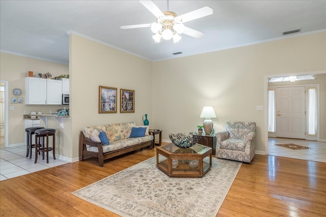 living room with light wood-type flooring and crown molding