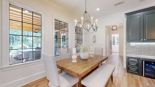 7827 Metcalf Rd, Thomasville, GA 31792 - dining room featuring a chandelier, light wood finished floors, crown molding, wine cooler, and recessed lighting
