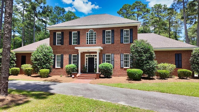 7827 Metcalf Rd, Thomasville, GA 31792 - colonial-style house with brick siding, roof with shingles, and a front lawn