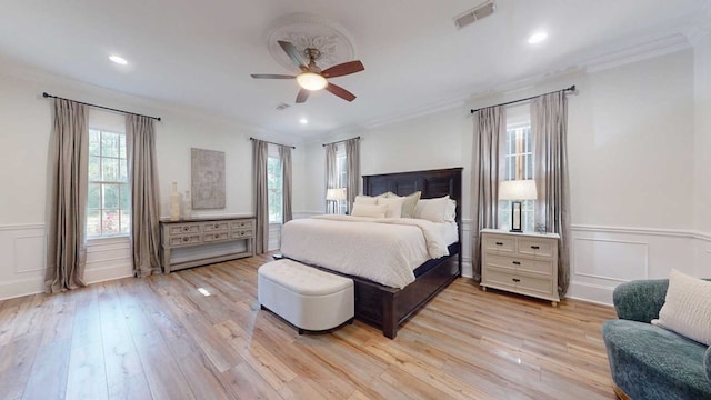 7827 Metcalf Rd, Thomasville, GA 31792 - bedroom with crown molding, wainscoting, light wood-type flooring, a decorative wall, and a ceiling fan