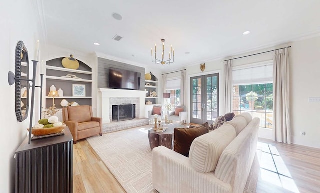 7827 Metcalf Rd, Thomasville, GA 31792 - living area with a brick fireplace, light wood-style floors, built in features, a chandelier, and ornamental molding