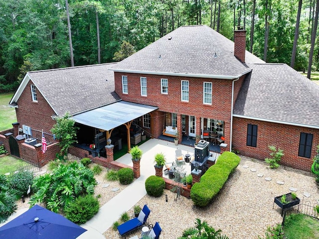 7827 Metcalf Rd, Thomasville, GA 31792 - rear view of property featuring outdoor lounge area, a shingled roof, a chimney, a patio, and brick siding