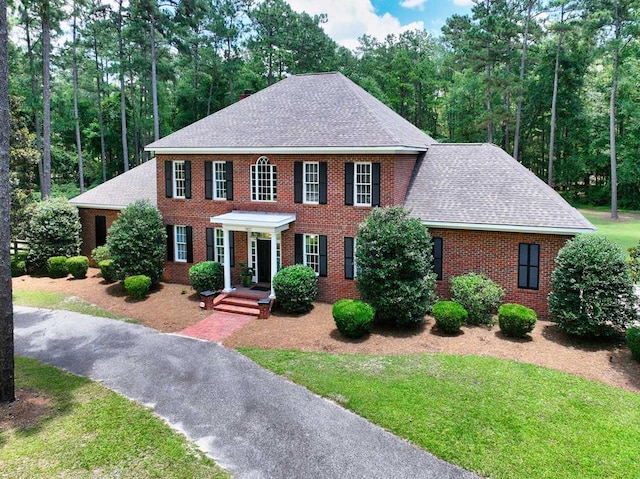 7827 Metcalf Rd, Thomasville, GA 31792 - colonial house featuring roof with shingles, brick siding, and a front yard