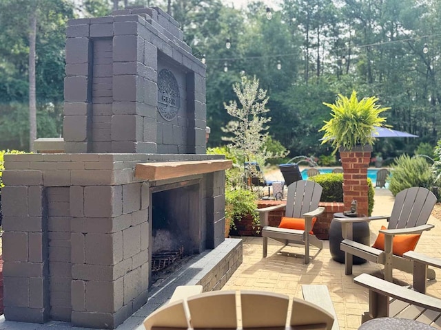7827 Metcalf Rd, Thomasville, GA 31792 - view of patio featuring an outdoor brick fireplace, an outdoor pool, and view of scattered trees