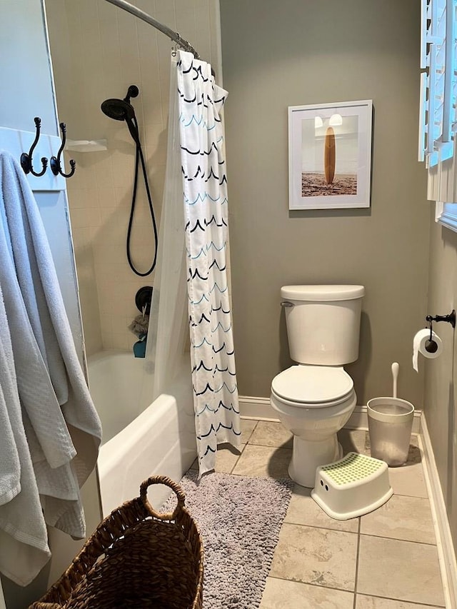 full bath featuring tile patterned flooring, toilet, shower / tub combo with curtain, and baseboards