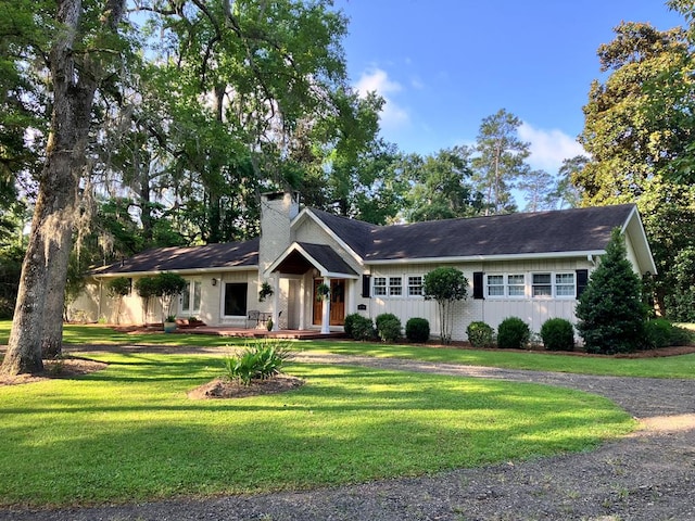 ranch-style house featuring a front yard and a chimney