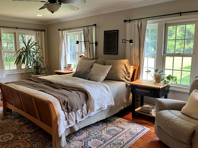 bedroom with a ceiling fan, dark wood-type flooring, and crown molding