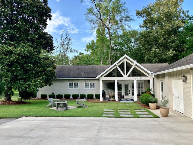 back of property featuring a patio, a yard, and brick siding