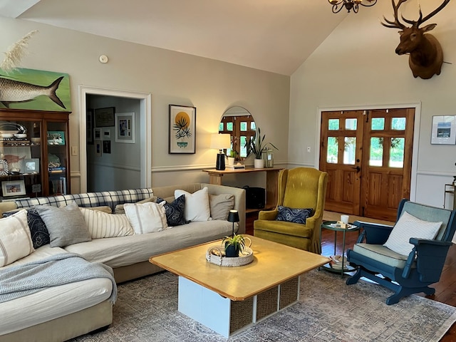 living area with wood finished floors and high vaulted ceiling