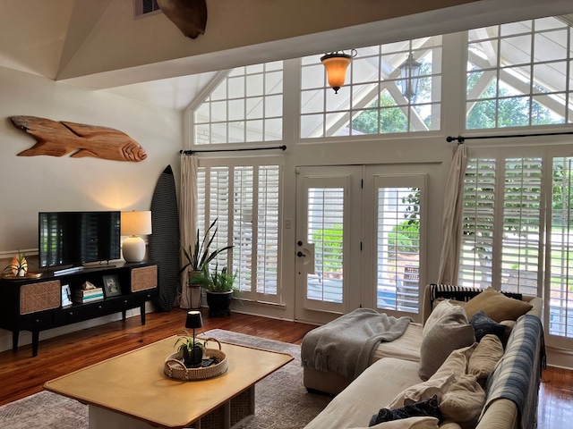 living room with visible vents, wood finished floors, and a towering ceiling