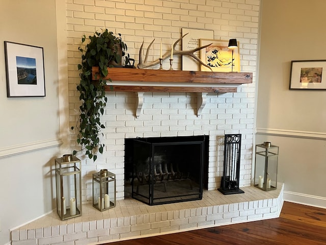 interior details with a fireplace, wood finished floors, and baseboards