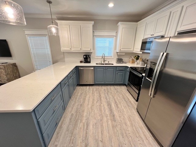 kitchen with sink, decorative light fixtures, white cabinets, and appliances with stainless steel finishes