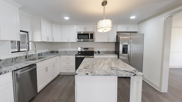 kitchen featuring a sink, a kitchen island, dark wood finished floors, stainless steel appliances, and decorative backsplash