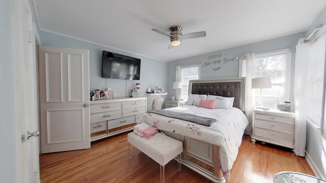 bedroom featuring crown molding, ceiling fan, and light wood-type flooring