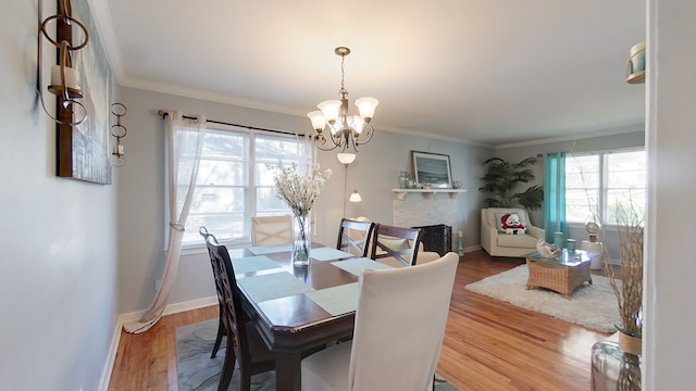 dining area featuring crown molding, wood-type flooring, and a chandelier