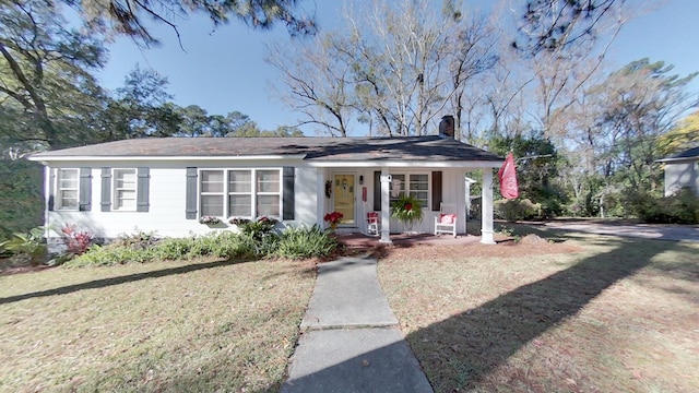 ranch-style home with a front yard and covered porch