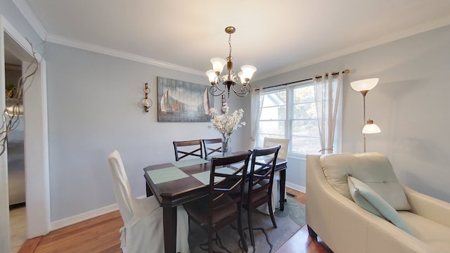 dining space with hardwood / wood-style flooring, ornamental molding, and a chandelier