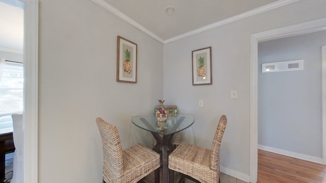 dining area featuring crown molding and light hardwood / wood-style floors