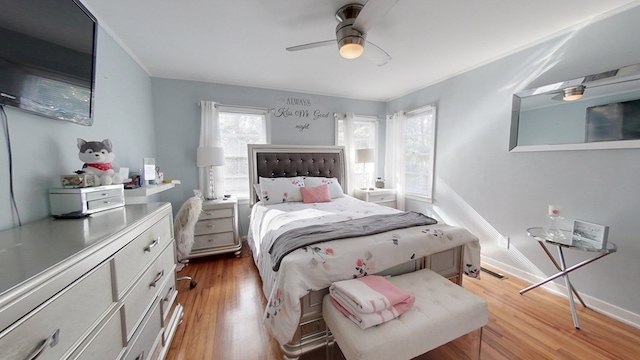 bedroom featuring ceiling fan, ornamental molding, and light hardwood / wood-style flooring