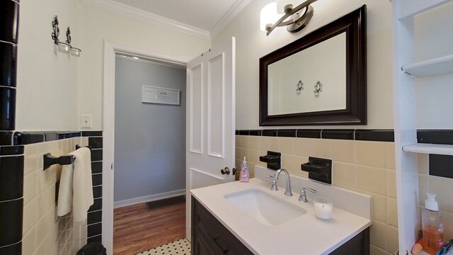 bathroom featuring hardwood / wood-style floors, ornamental molding, tile walls, and vanity