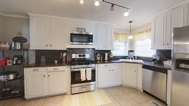 kitchen with pendant lighting, stainless steel appliances, sink, and white cabinets